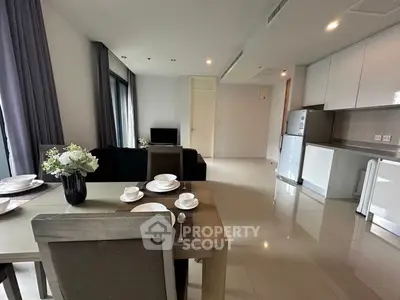 Modern open-plan living room and kitchen with elegant dining area and sleek appliances.