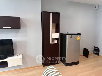 Modern living room with sleek furniture and stainless steel fridge, perfect for contemporary urban living.