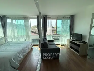 Modern studio apartment with large windows and natural light