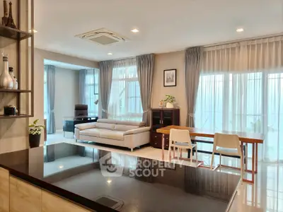 Spacious modern living room with elegant decor and large windows offering natural light.