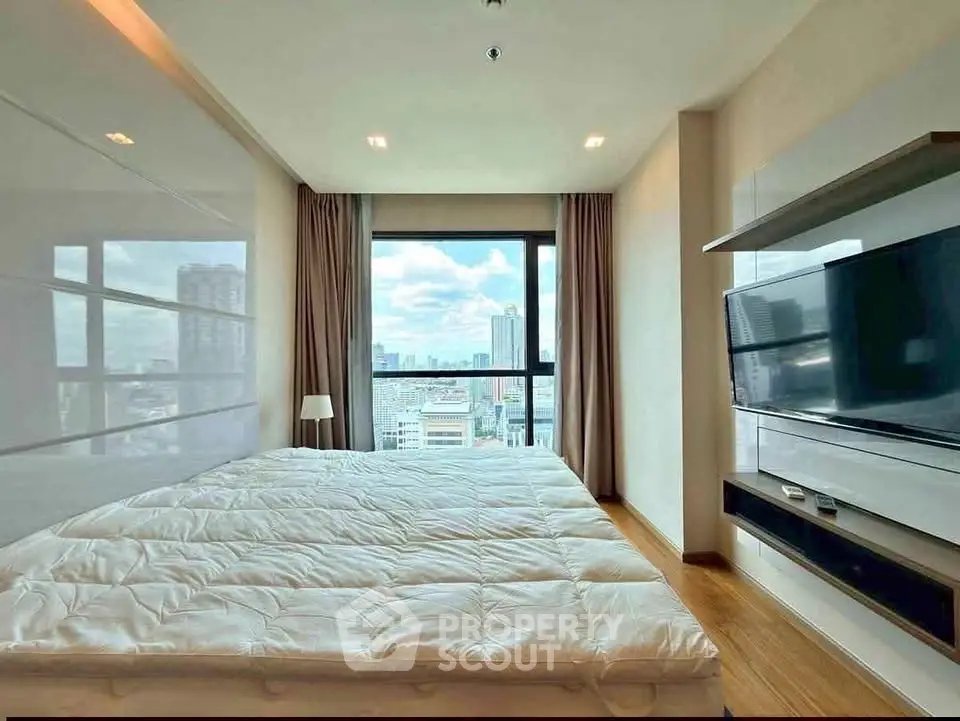 Modern bedroom with city view, featuring sleek design and large window for natural light.