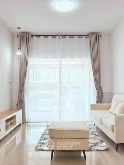 Bright and cozy living room with modern furniture and large window view.