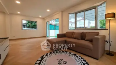 Spacious living room with modern sofa and large windows offering natural light.