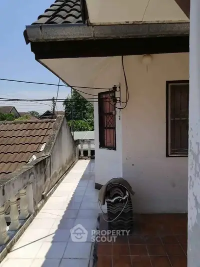 Charming exterior view of a residential property with tiled roof and balcony.