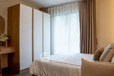 Cozy bedroom with modern wardrobe and large window for natural light