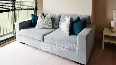 Cozy living room with modern gray sofa and stylish cushions near window