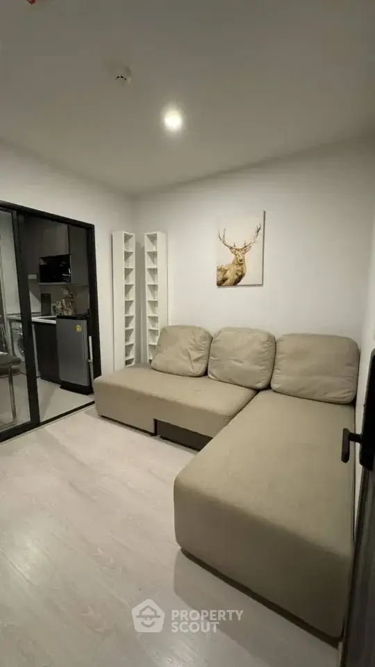 Modern living room with beige sectional sofa and glass partition to kitchen