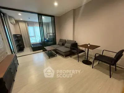 Modern living room with sleek furniture and large windows offering natural light.