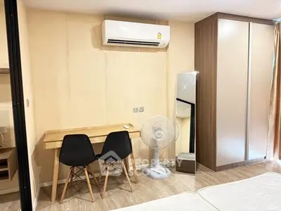 Modern bedroom with sleek wardrobe, desk, and air conditioning unit.