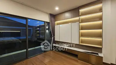 Modern living room with elegant built-in shelves and large sliding glass doors opening to a balcony.