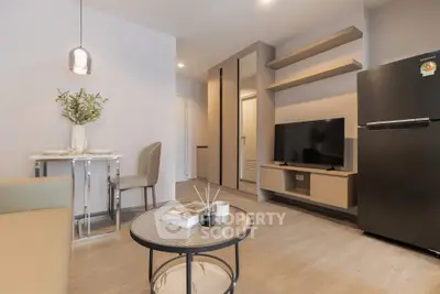 Modern living room with sleek furniture and open layout, featuring a stylish TV setup and dining area.