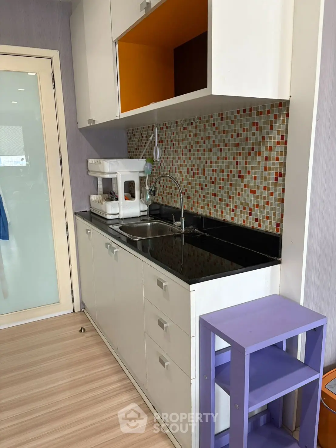 Modern kitchen with sleek cabinetry and colorful mosaic backsplash