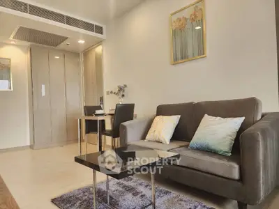 Modern living room with stylish sofa, elegant decor, and cozy dining area in a contemporary apartment.