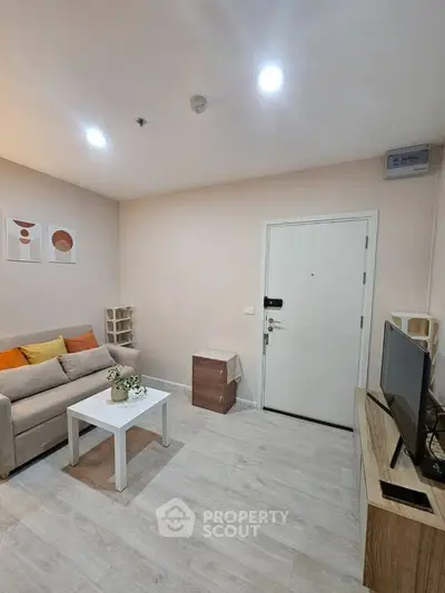 Modern living room with cozy sofa, stylish decor, and sleek TV setup in a contemporary apartment.