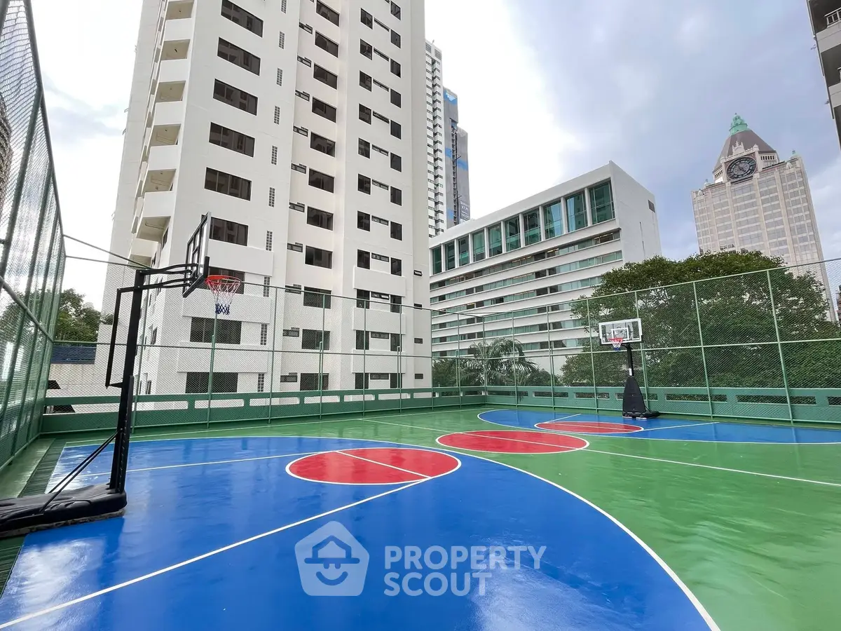 Modern urban basketball court with skyscraper backdrop, perfect for active city living.