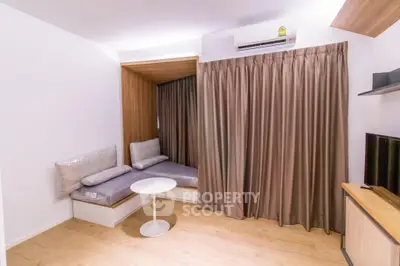 Modern living room with cozy seating area and air conditioning, featuring stylish curtains and wooden flooring.