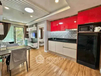 Modern open-layout kitchen and living room with vibrant red cabinets and sleek design.