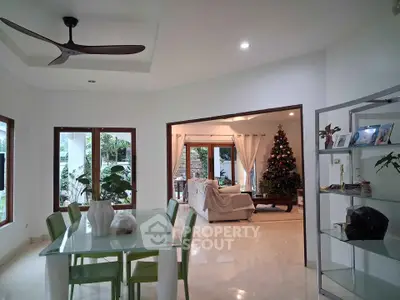 Spacious living and dining area with modern decor and Christmas tree, perfect for festive gatherings.
