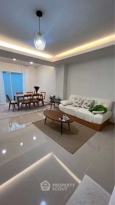 Spacious modern living room with elegant dining area and stylish decor.