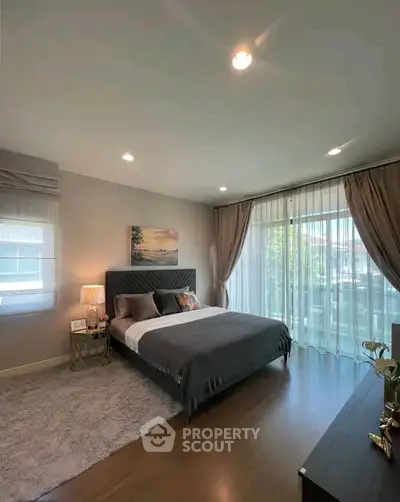 Spacious bedroom with elegant decor and large windows for natural light