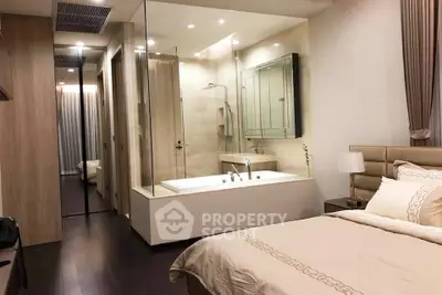 Luxurious bedroom with ensuite glass shower and bathtub, elegant decor and cozy ambiance.