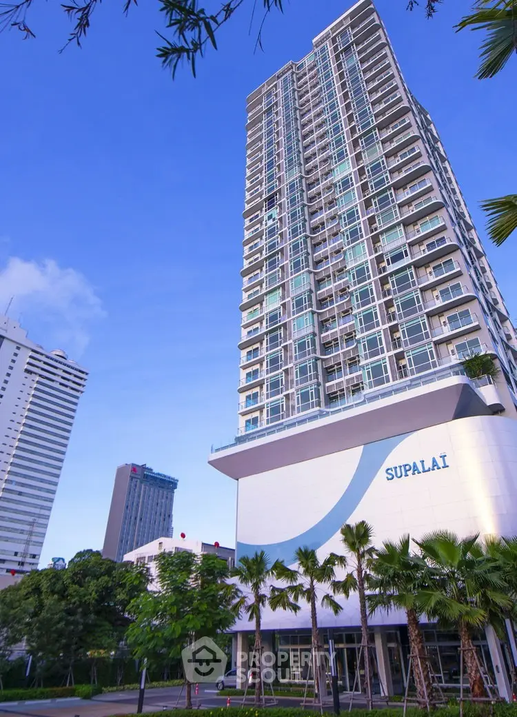 Stunning high-rise building with modern architecture and lush greenery in urban setting.