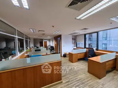 Spacious modern office space with wooden desks and large windows