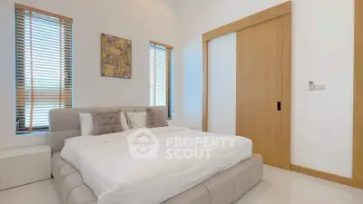 Modern bedroom with cozy bed and stylish decor in a bright, airy space.