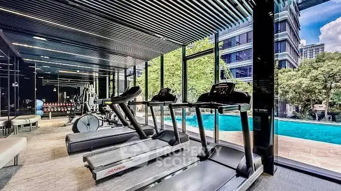 Luxurious gym with pool view in modern residential building