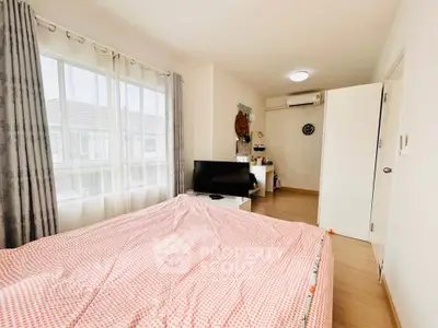 Bright and cozy bedroom with large window and modern furnishings in a stylish home.