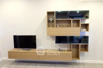 Modern living room with stylish wooden wall-mounted TV unit and decorative shelves.