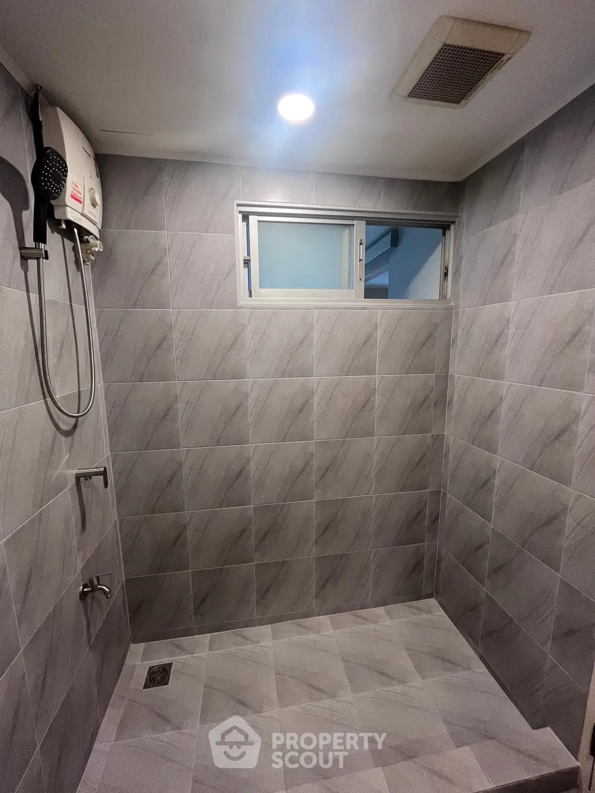 Modern bathroom with sleek gray tiles and built-in shower heater
