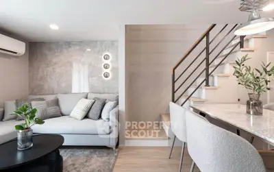 Modern living room with stylish decor and staircase in a cozy apartment.