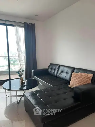 Modern living room with sleek black leather sofa and city view balcony.