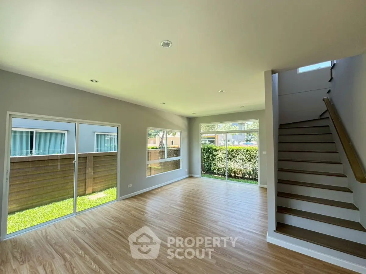 Spacious modern living room with large windows and wooden flooring