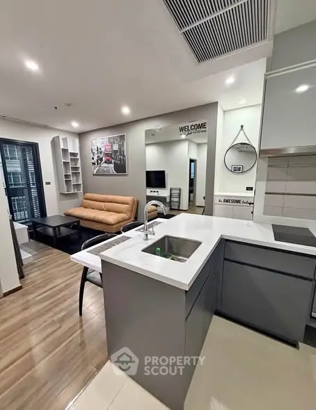 Modern open-plan living room and kitchen with sleek design and stylish decor.