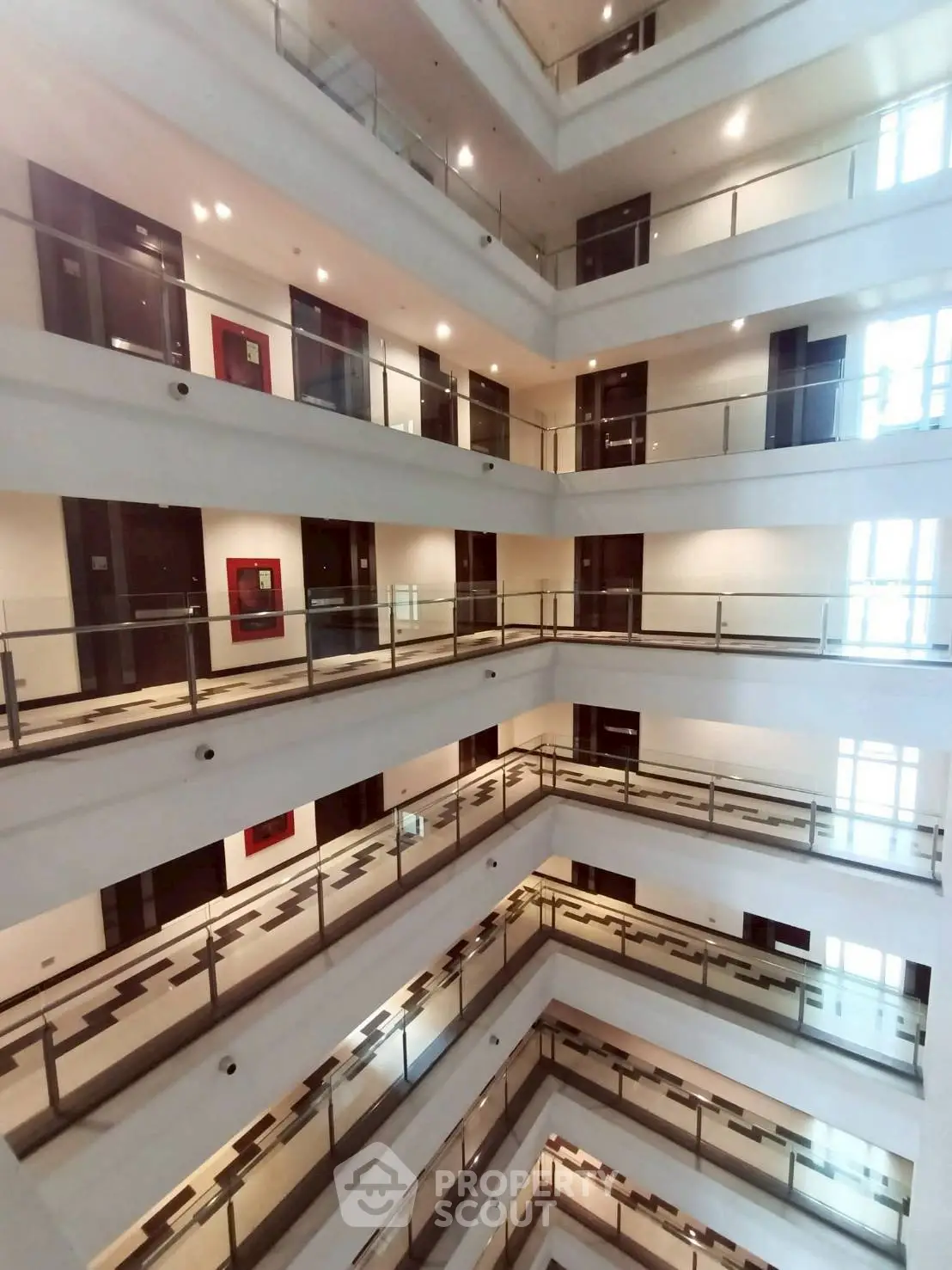 Modern multi-story building interior with glass railings and bright lighting