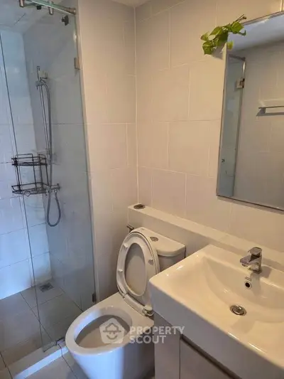 Modern bathroom with glass shower and sleek fixtures in a contemporary apartment.