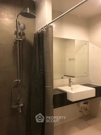 Modern bathroom with sleek shower and stylish sink in contemporary apartment.