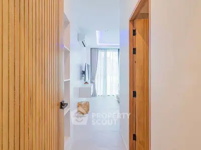 Modern apartment entrance with sleek wooden door and bright interior design.