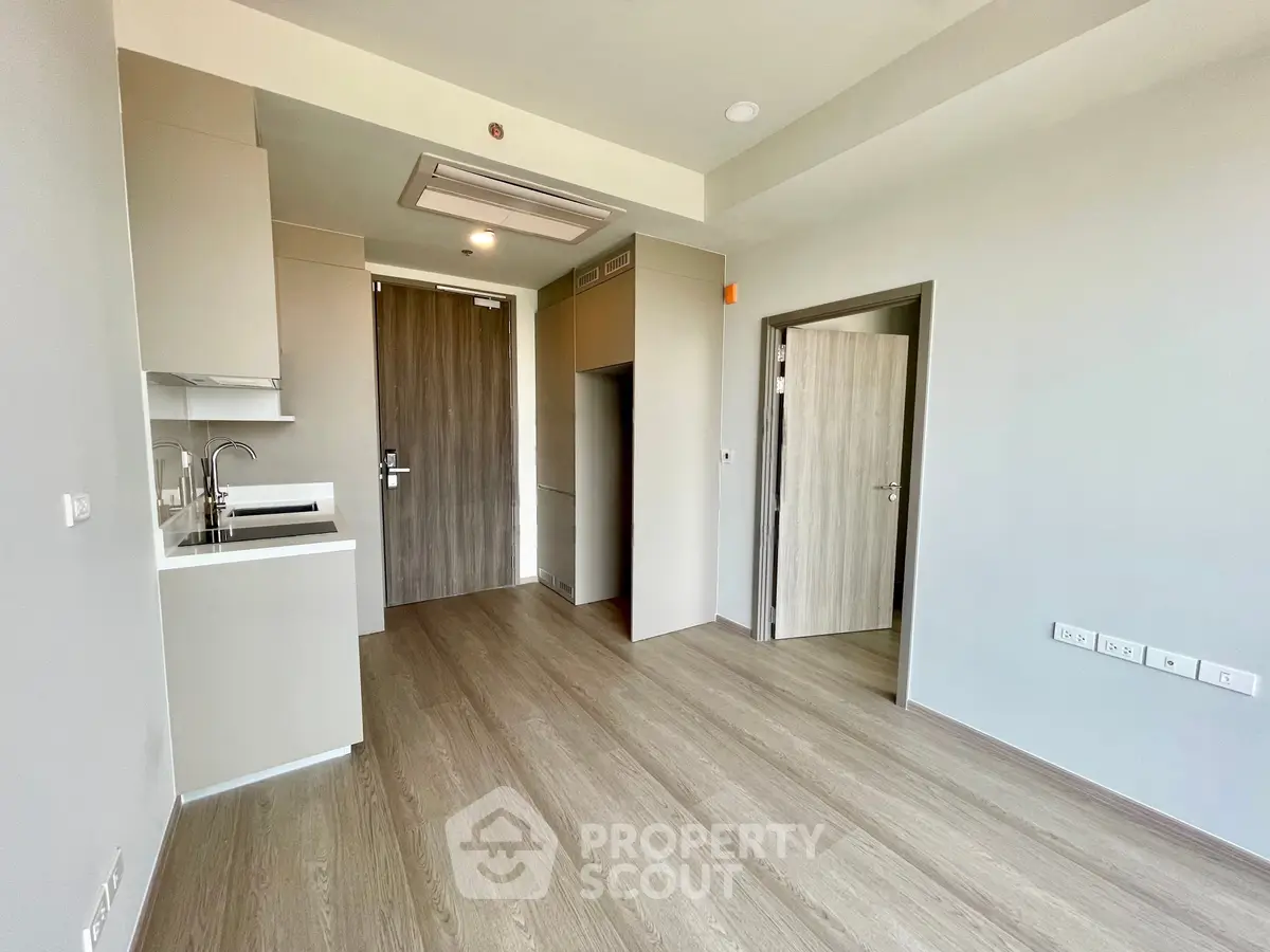 Modern minimalist apartment interior with sleek kitchen and wooden flooring