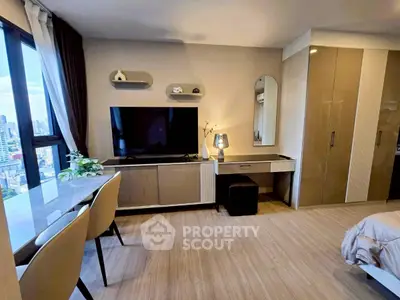 Modern bedroom with city view, sleek furniture, and ample natural light.