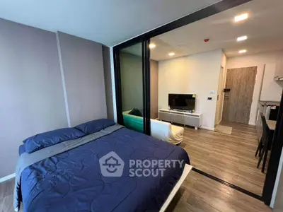 Modern bedroom with glass partition and cozy living area in stylish apartment.