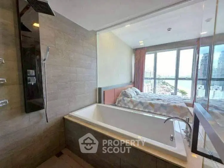 Luxurious bathroom with bathtub and city view from adjacent bedroom