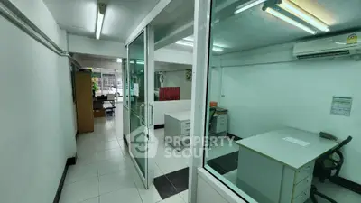 Spacious office space with glass partitions and modern lighting