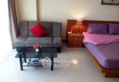 Cozy bedroom with modern decor and a small sitting area.