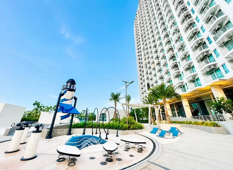 Modern high-rise building with outdoor recreational area and playground.
