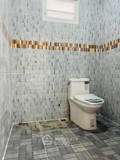 Modern bathroom with stylish tile design and contemporary toilet fixture.