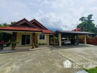 Charming suburban house with spacious driveway and carport, featuring red-tiled roof and lush greenery.