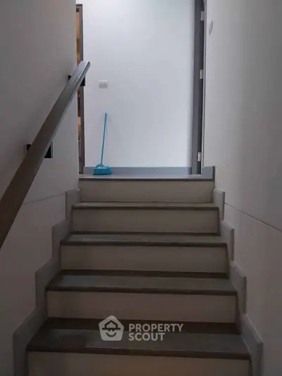 Modern interior staircase with sleek handrail and minimalist design.